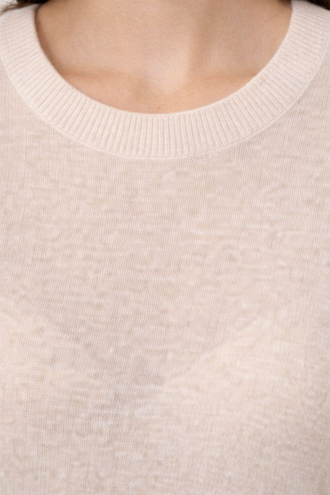 Close-up of the Amara crewneck in ivory, showing fine knit texture and neckline detail